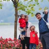 Cả gia đình cùng nhau ghi lại khoảnh khắc của mùa Xuân bên hồ Gươm (1/2023). (Ảnh: Thanh Tùng/TTXVN)