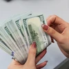 Chuyển từ 1.000 USD ra nước ngoài phải báo cáo. (Ảnh: Vietnam+)