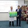 Đồng chí Hồng Quang - Thành viên Hội đồng quản trị, Chủ tịch Công đoàn Vietcombank (bên phải) trao biển tượng trưng hỗ trợ 500 triệu đồng cho Bệnh viện Đa khoa Khu vực Hóc Môn. (Ảnh: Vietnam+) 