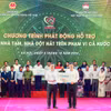 Ông Nguyễn Thanh Tùng (bên trái) - Bí thư Đảng ủy, Chủ tịch HĐQT Vietcombank trao tượng trưng kinh phí 100 tỷ đồng hỗ trợ xoá nhà tạm, nhà dột nát ủng hộ cho địa phương. (Ảnh: Vietnam+)