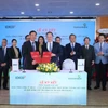 Ông Lê Quang Vinh – Thành viên HĐQT, Tổng Giám đốc Vietcombank (bên phải) và ông Đặng Chính Trung – Thành viên HĐQT, Tổng Giám đốc IDICO (bên trái) đại diện hai đơn vị hoàn thành nghi thức ký kết thỏa thuận hợp tác trước sự chứng kiến của các đại biểu. (Ảnh: Vietnam+)