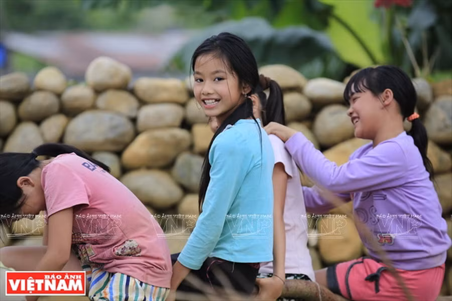 Những đứa trẻ người Giáy vui chơi bên hàng rào đá độc đáo của bản. (Ảnh: Việt Cường)