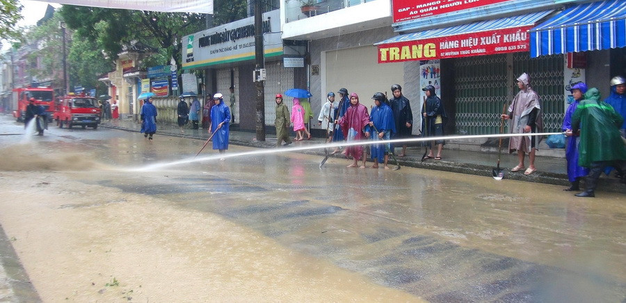 Các lực lượng Công an, đoàn viên thanh niên tham gia hỗ trợ người dân dọn vệ sinh sau lụt. (Ảnh: Tường Vi/TTXVN)