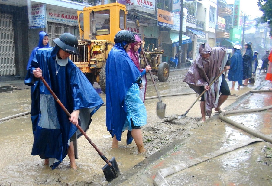 Các lực lượng Công an, đoàn viên thanh niên tham gia hỗ trợ người dân dọn vệ sinh sau lụt. (Ảnh: Tường Vi/TTXVN)