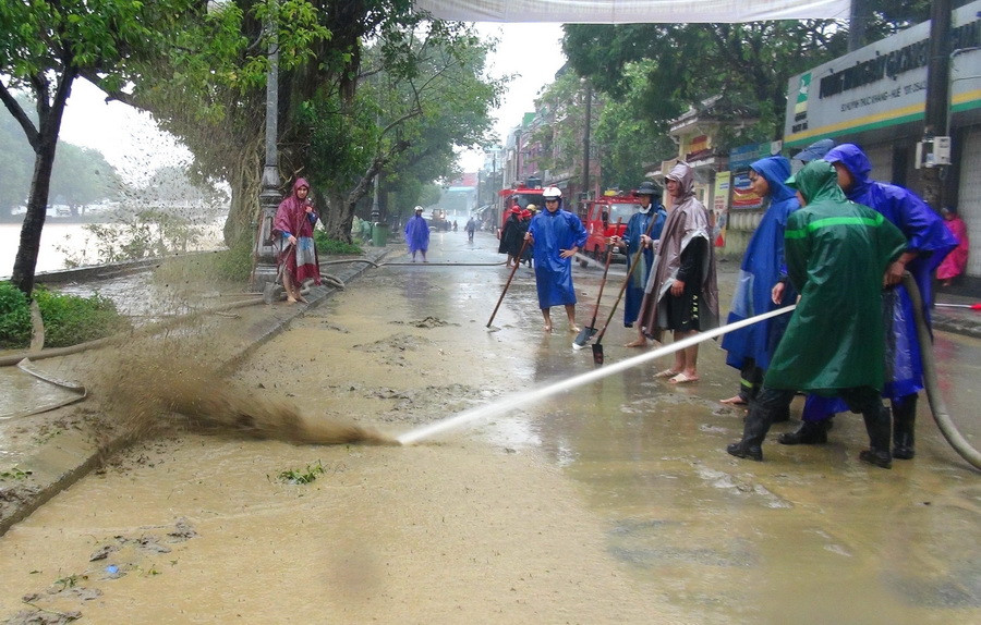 Các lực lượng Công an, đoàn viên thanh niên tham gia hỗ trợ người dân dọn vệ sinh sau lụt. (Ảnh: Tường Vi/TTXVN)