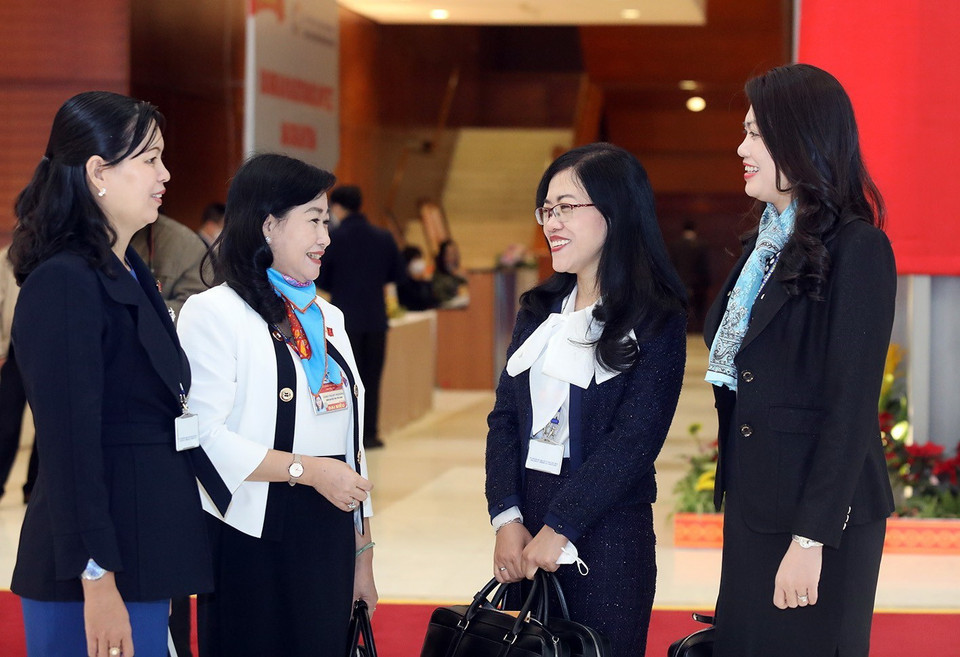 Các nữ đại biểu trao đổi trước khi bước vào phiên họp sáng 29/1. (Ảnh: TTXVN)