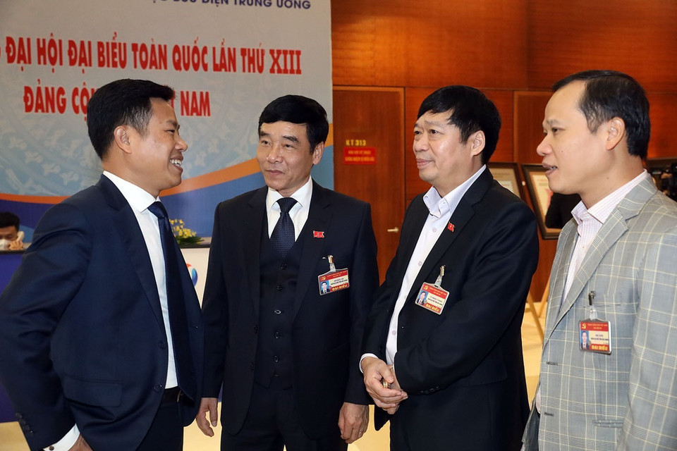 Các đại biểu trao đổi bên lề phiên thảo luận các văn kiện đại hội, sáng 28/1. (Ảnh: TTXVN)