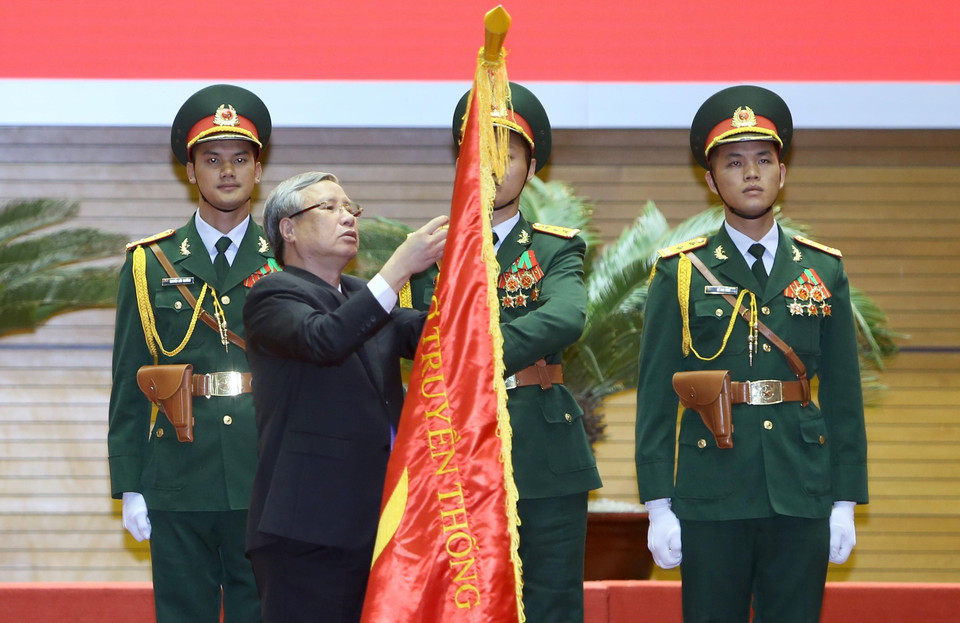 Ông Trần Quốc Vượng, Ủy viên Bộ Chính trị, Thường trực Ban Bí thư Trung ương Đảng gắn Huân chương Sao vàng của Chủ tịch nước lên Cờ truyền thống của Lực lượng chuyên gia Việt Nam giúp Cách mạng Campuchia. (Ảnh: Dương Giang/TTXVN)