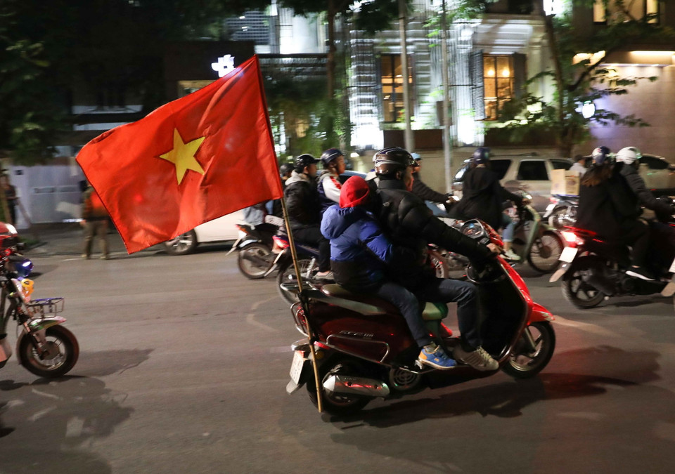 Cổ động viên mang theo cờ Tổ quốc đi trên các tuyến phố của Hà Nội để mừng chiến thắng của đội tuyển U22 Việt Nam. (Ảnh: Thanh Tùng/TTXVN)