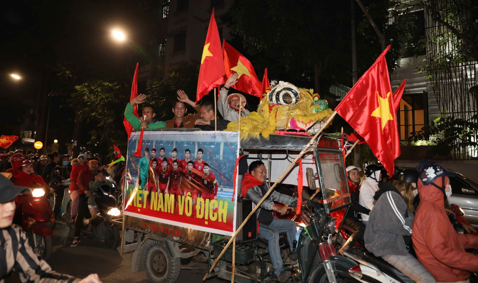 Cổ động viên mang theo cờ Tổ quốc đi trên các tuyến phố của Hà Nội để mừng chiến thắng của đội tuyển U22 Việt Nam. (Ảnh: Thanh Tùng/TTXVN)