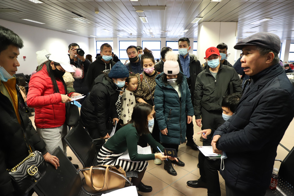 Ông Đặng Trần Phong (phải) thăm hỏi kiều bào ở sân bay thủ đô Bucharest, Romania. (Ảnh: Mạnh Hùng/TTXVN)