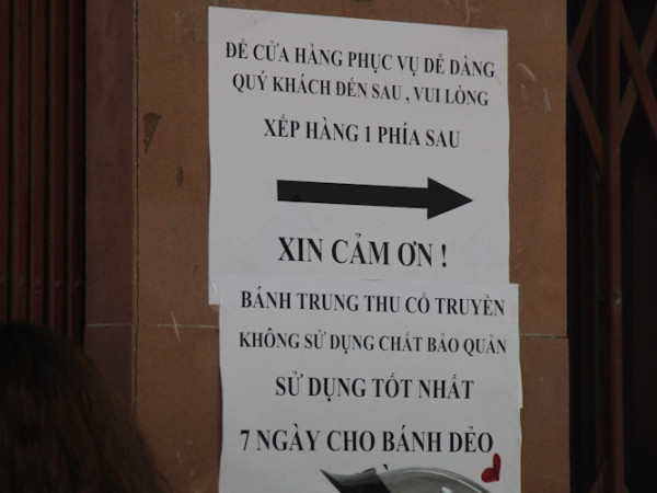 Chủ cửa hàng dán sẵn hướng dẫn xếp hàng và cách sử dụng bánh ngay trước cửa nhà. (Ảnh: Minh Sơn/Vietnam+)