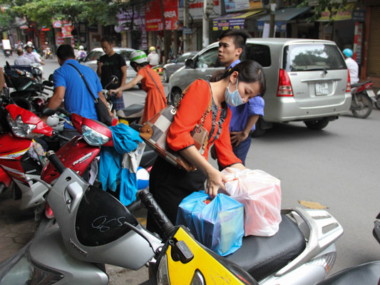 Chị Hoa từ Hoàng Cầu đến tận Thụy Khuê mua bánh, tưởng lúc trưa sẽ ít người mua, nhưng chị vẫn phải xếp hàng chờ hơn 30 phút. (Ảnh: Minh Sơn/Vietnam+)