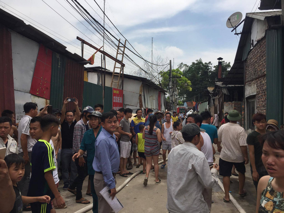 Nhiều người dân sống xung quanh khu vực đám cháy tỏ ra hoảng hốt khi khói đen kịt bốc lên bao trùm. (Ảnh: PV/Vietnam+) 