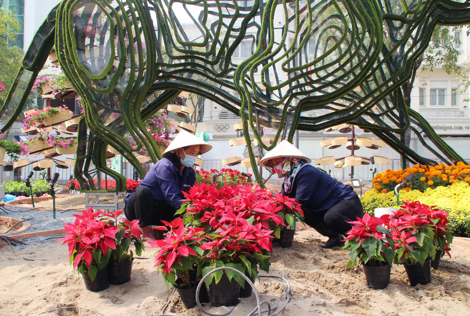 Để thực hiện những tiểu cảnh của Đường hoa Nguyễn Huệ Tết Nhâm Dần 2022, đội ngũ thi công thiết kế phần thô, sau đó lựa chọn chủng loại hoa phù hợp để tạo hình. (Ảnh: Mỹ Phương/TTXVN)