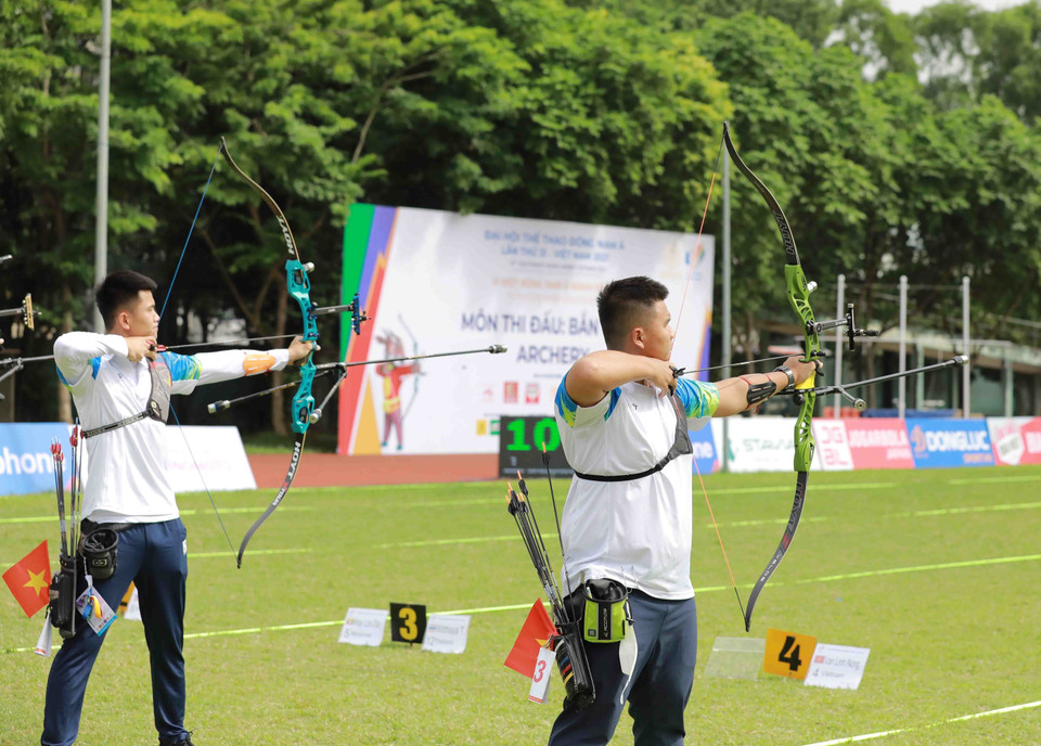 Vận động viên Nông Văn Linh (dân tộc Tày-Việt Nam) và vận động viên Nguyễn Duy (Việt Nam-phải) thi đấu nội dung cung 1 dây cá nhân nam. (Ảnh: Vũ Sinh/TTXVN)