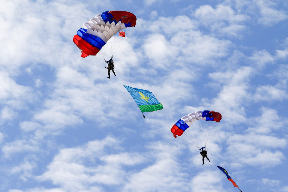 Các vận động viên nhảy dù mang cờ truyền thống của các quân binh chủng trong lực lượng vũ trang Nga tới thao trường Alabino. (Ảnh: Trần Hiếu/TTXVN)