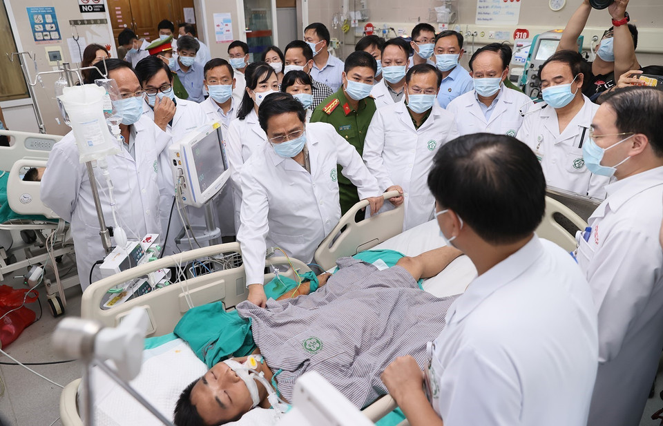 Thủ tướng Phạm Minh Chính thăm hỏi sức khỏe các nạn nhân đang điều trị tại Bệnh viện Bạch Mai. (Ảnh: Dương Giang/TTXVN)