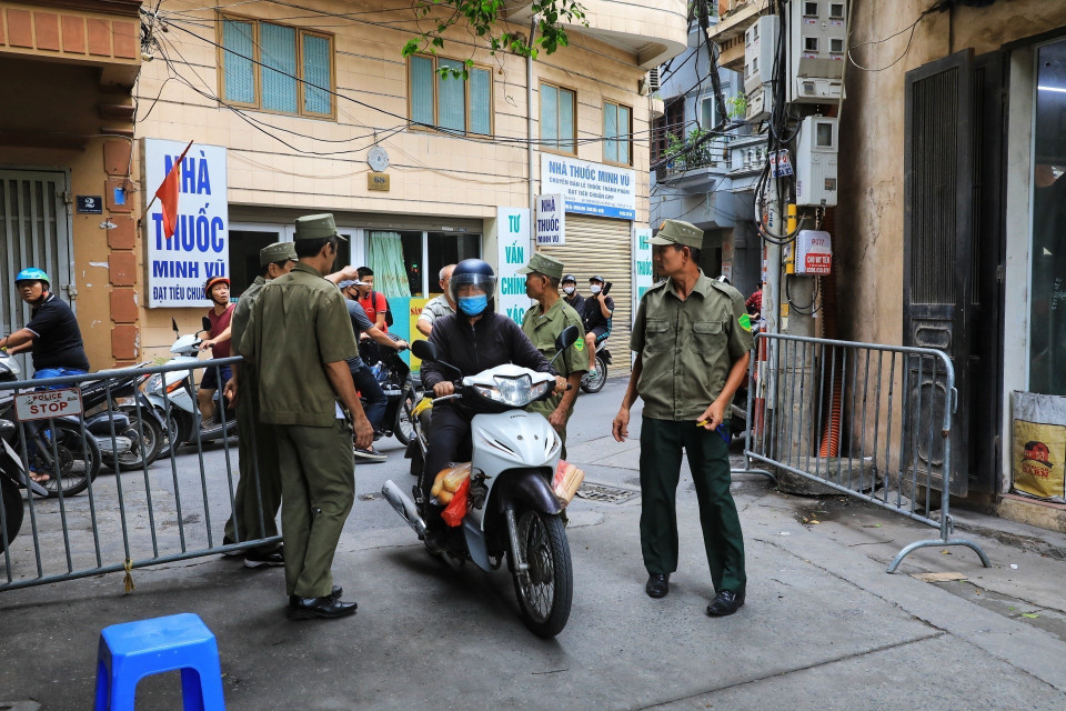 Các lực lượng chức năng lập hàng rào ngăn các phương tiện di chuyển vào trong khu vực phong tỏa. (Ảnh: Tuấn Anh/TTXVN)