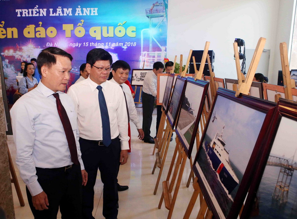 Ủy viên Trung ương Đảng, Tổng Giám đốc TTXVN Nguyễn Đức Lợi (bên trái) và Phó Bí Thư thường trực Thành ủy Đà Nẵng Võ Công Trí tham quan triển lãm ảnh. (Ảnh: Trần Lê Lâm/TTXVN)