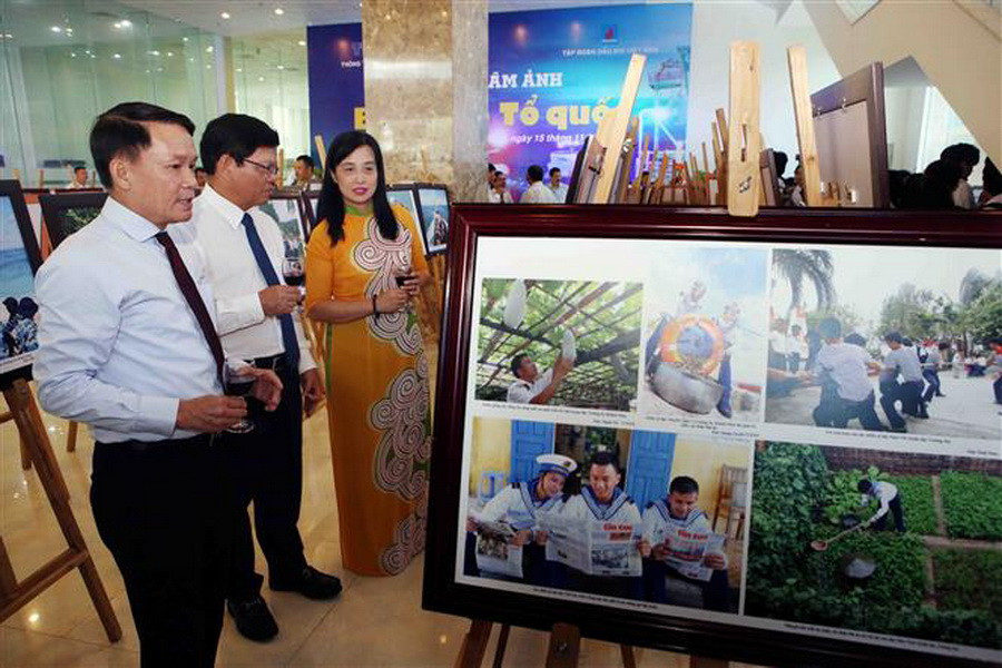 Ủy viên Trung ương Đảng, Tổng Giám đốc TTXVN Nguyễn Đức Lợi (bên trái) và Phó Bí Thư thường trực Thành ủy Đà Nẵng Võ Công Trí tham quan triển lãm ảnh. (Ảnh: Trần Lê Lâm/TTXVN)