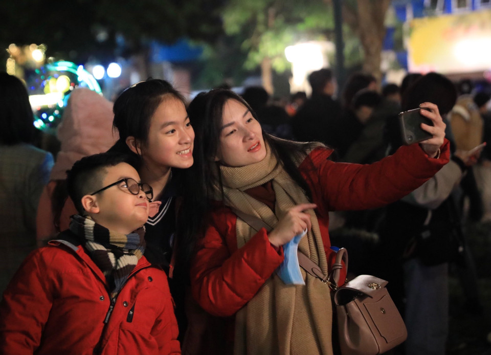 Người dân ghi lại khoảnh khắc đầu tiên của Năm mới 2023. (Ảnh: Hoàng Hiếu/TXVN)