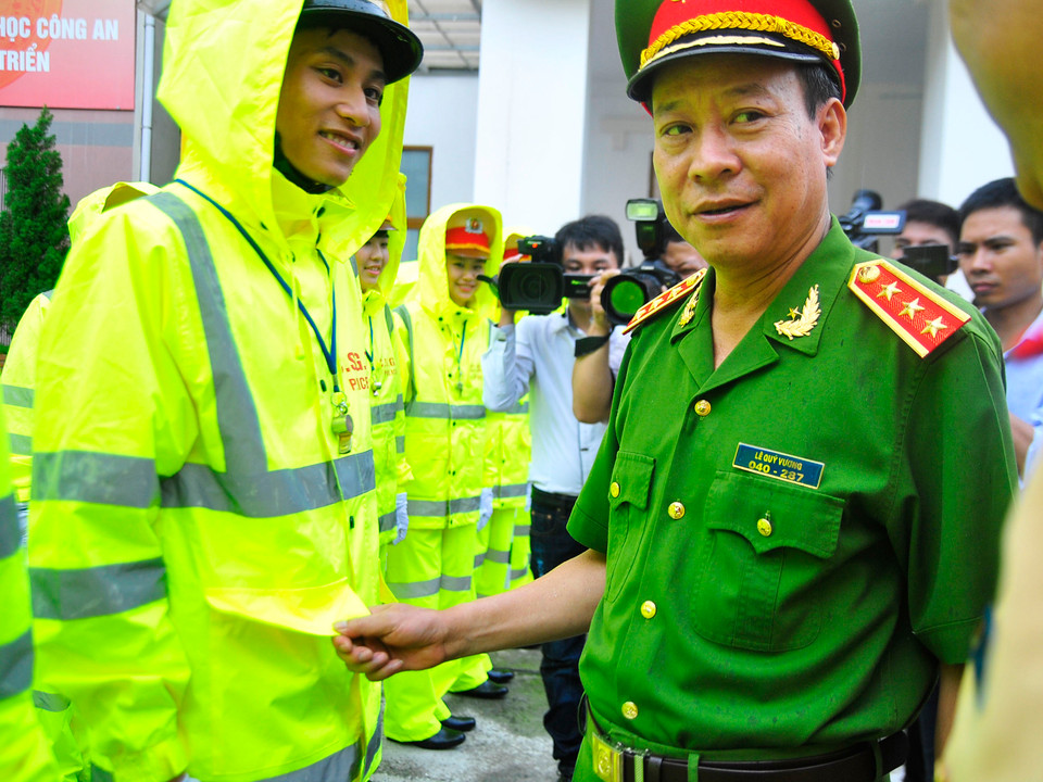 Thượng tướng Lê Quý Vương kiểm tra mẫu áo mưa và thăm hỏi các chiến sĩ cảnh sát giao thông.