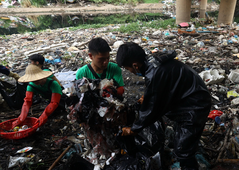 Rác được gom cho vào túi để mang đến nơi tập kết. (Ảnh: Tuấn Anh/TTXVN)