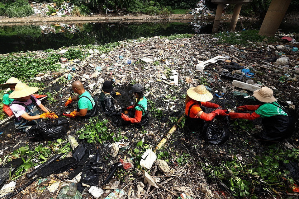 Số lượng rác dưới các dòng sông khá lớn nên tình nguyện viên rất vất vả để thu gom, dọn dẹp. (Ảnh: Tuấn Anh/TTXVN)