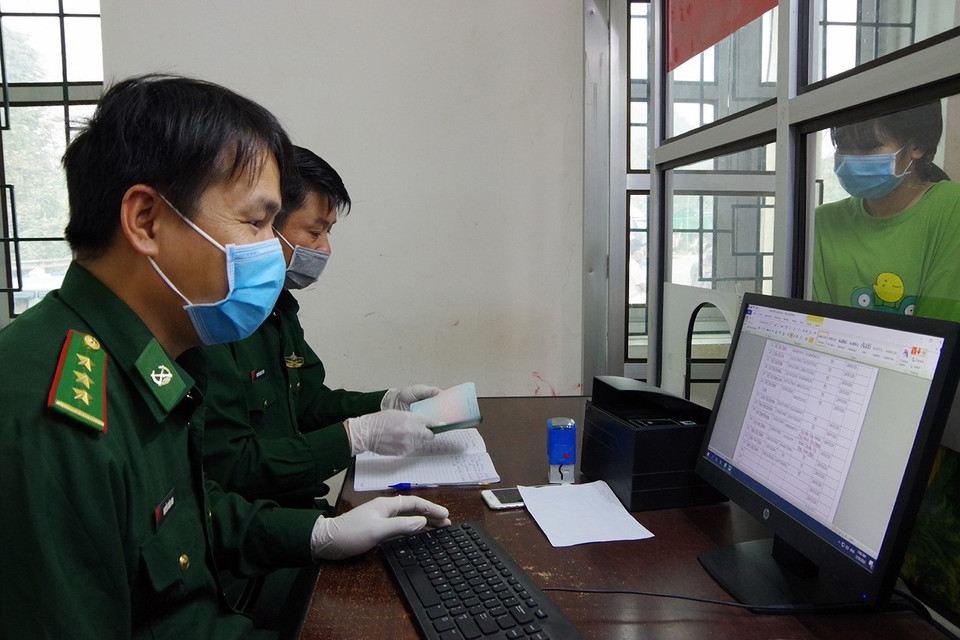 Cán bộ chiến sỹ Trạm kiểm soát Biên phòng Cửa khẩu Quốc tế Tây Trang làm thủ tục nhập cảnh cho công dân Việt Nam từ Lào trở về. (Ảnh: Phan Tuấn Anh/TTXVN)