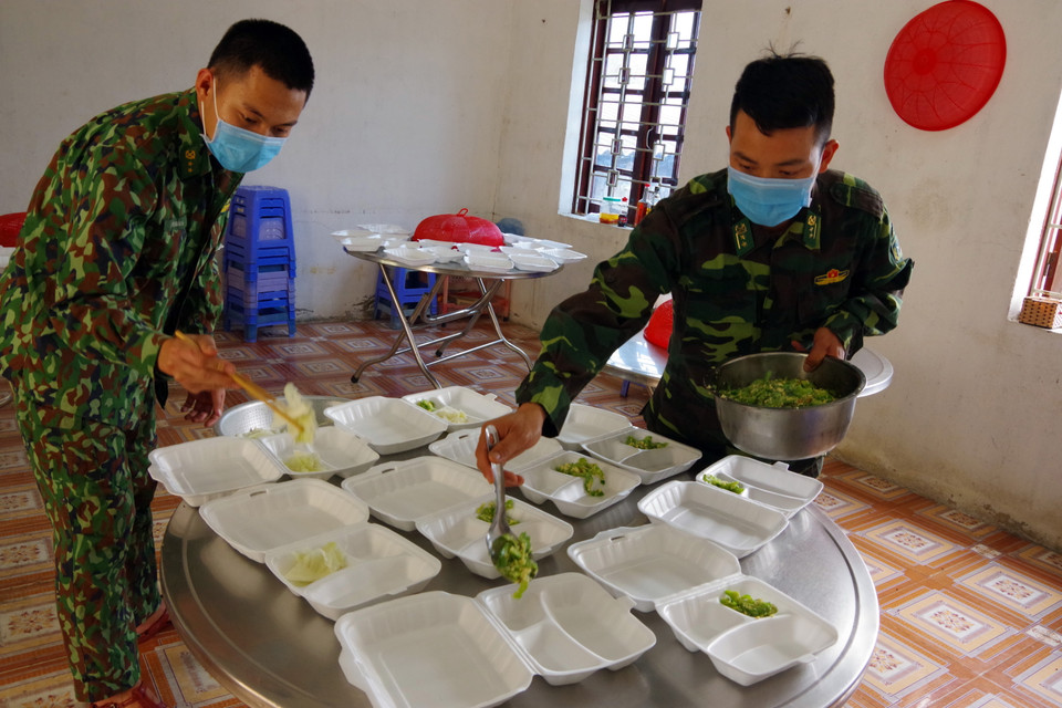 Cán bộ chiến sỹ Trạm kiểm soát Biên phòng Cửa khẩu Quốc tế Tây Trang chuẩn bị các suất cơm miễn phí phát cho người dân. (Ảnh: Phan Tuấn Anh/TTXVN)