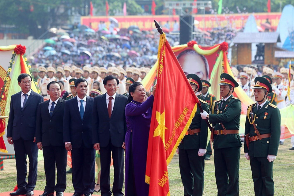 Đồng chí Tòng Thị Phóng, Ủy viên Bộ Chính trị, Phó Chủ tịch Thường trực Quốc hội gắn Huân chương Độc lập hạng Nhất lên lá cờ danh dự. (Ảnh: Phan Tuấn Anh/TTXVN)