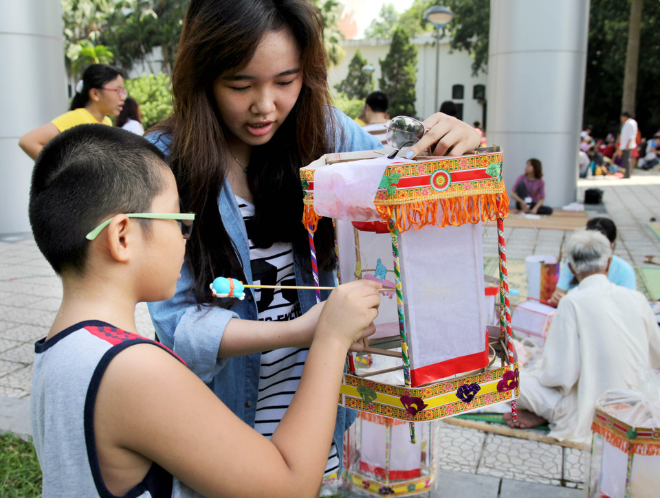 Hai bạn nhỏ thích thú khi có một chiếc đèn kéo quân về chơi Trung Thu. (Ảnh: Doãn Đức/ Vietnam+)