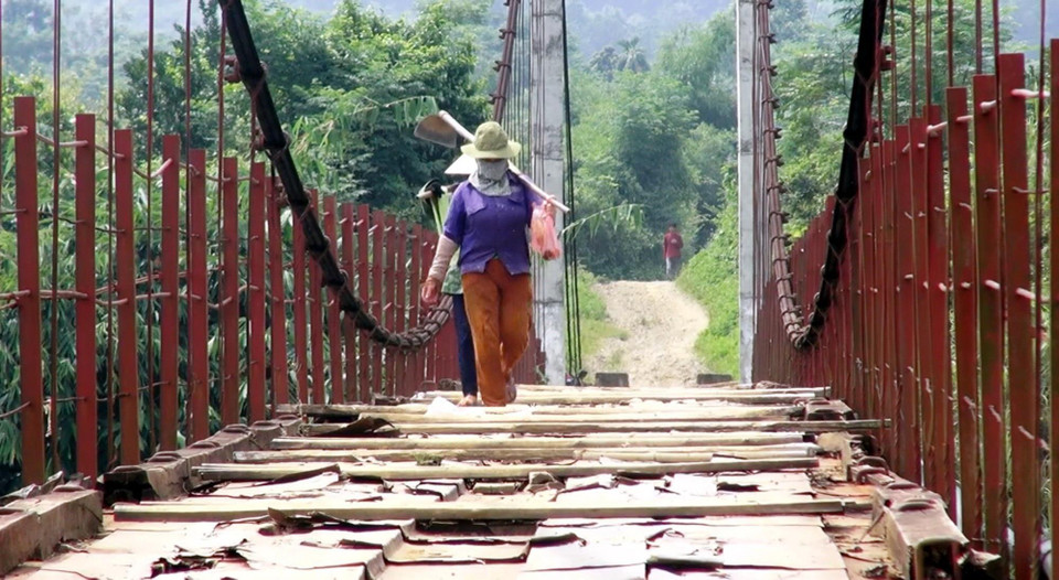 Người dân lưu thông khó khăn trên cầu treo xuống cấp. (Ảnh: Thanh Hải/TTXVN)