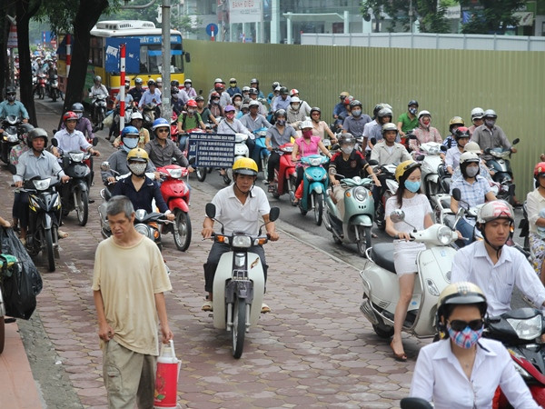 Nhiều xe máy đã phải trèo lên vỉa hè để di chuyển. (Ảnh: Minh Sơn/Vietnam+)