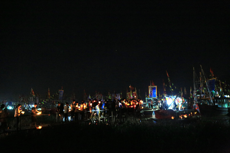 Hàng trăm thanh niên nam, nữ đi thả hoa đăng xuống sông Lục Đầu. (Ảnh: Mạnh Tú/TTXVN)