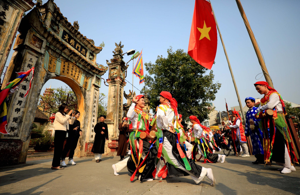 Điệu "múa bồng" cổ do trai làng đóng giả làm con gái, má phấn, môi son, đầu chít khăn mỏ quạ, váy nhiễu màu đen với những dải màu ngũ sắc, vừa múa nhún nhảy, vừa vỗ trống bồng đeo trước bụng một cách nhí nhảnh, duyên dáng trong ngày hội. (Ảnh: Nhật Anh/TTXVN)