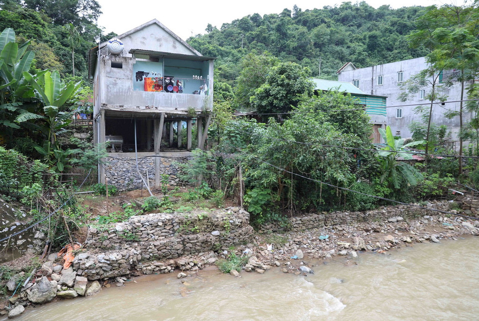 Để có mặt bằng làm nhà ven suối, người dân phải xây dựng hệ thống nhiều cột đỡ, bờ kè ven suối chống sạt lở, sụt trượt. (Ảnh: Xuân Tiến/TTXVN)