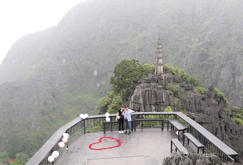 Du khách chụp ảnh lưu niệm trên đỉnh hang Múa. (Ảnh: Đức Phương/TTXVN)