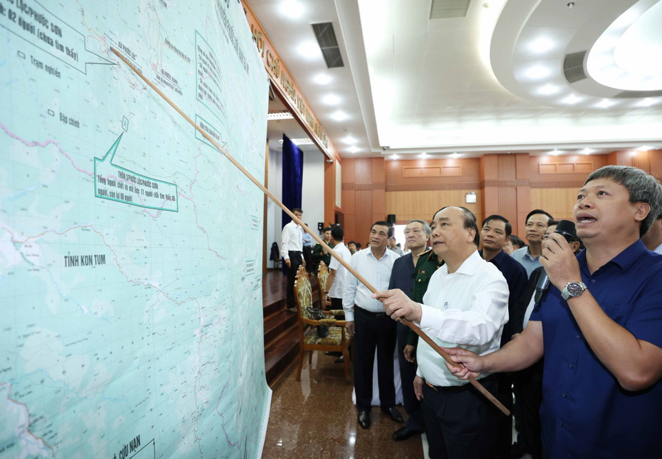 Thủ tướng Nguyễn Xuân Phúc và các đại biểu xem bản đồ chỉ huy cứu hộ, cứu nạn tại huyện Phước Sơn và Nam Trà My. (Ảnh: Thống Nhất/TTXVN)