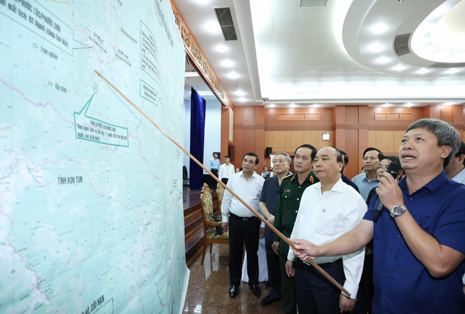 Thủ tướng Nguyễn Xuân Phúc và các đại biểu xem bản đồ chỉ huy cứu hộ, cứu nạn tại huyện Phước Sơn và Nam Trà My. (Ảnh: Thống Nhất/TTXVN)