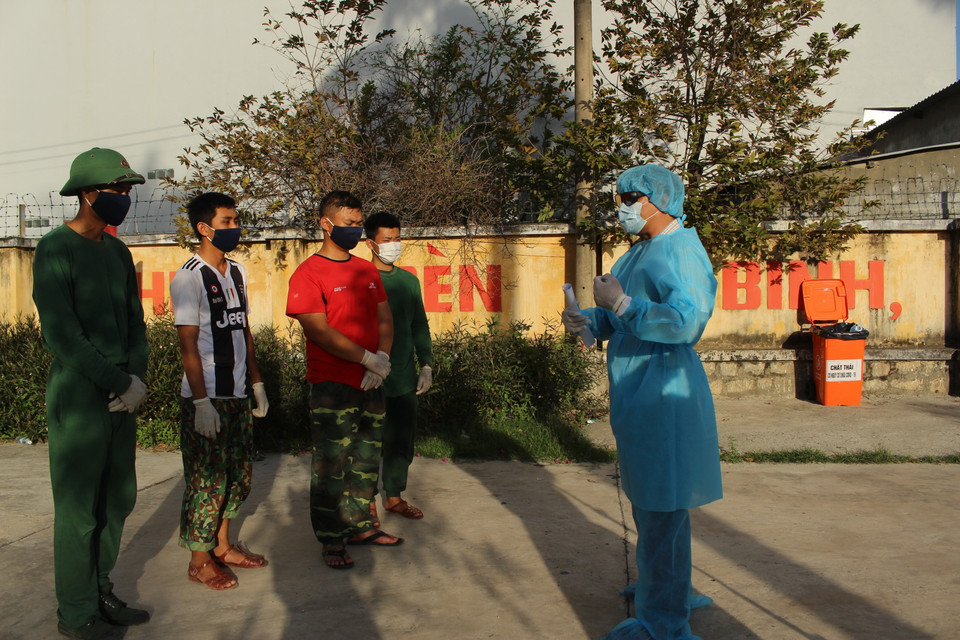 Từ tối 29/2, tỉnh Khánh Hòa đã đưa hai địa điểm thuộc đơn vị quân đội địa phương làm nơi tiếp nhận, cách ly những công dân Việt Nam trở về từ Hàn Quốc. Trong ảnh: Đại tá Trịnh Việt Thành (mặc đồ bảo hộ) thăm hỏi, dặn dò các chiến sỹ bộ đội phục vụ cách ly trong khu cách ly tập trung 14 ngày tại Trung tâm Huấn luyện, bồi dưỡng kiến thức quốc phòng-an ninh, thuộc Trung đoàn bộ binh 974, Bộ chỉ huy Quân sự tỉnh Khánh Hòa. (Ảnh: Phan Sáu/TTXVN)