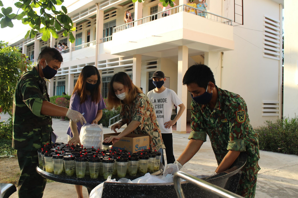 Các chiến sỹ bộ đội tiến phát cơm tối cho những người trong khu cách ly tại Trung tâm Huấn luyện, bồi dưỡng kiến thức quốc phòng-an ninh, thuộc Trung đoàn bộ binh 974, Bộ chỉ huy Quân sự tỉnh Khánh Hòa. (Ảnh: Phan Sáu/TTXVN)