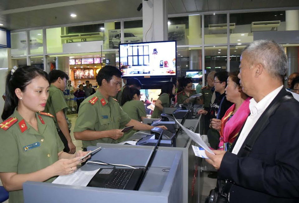 Cán bộ Phòng Quản lý xuất nhập cảnh, Công an tỉnh Thừa Thiên-Huế làm thủ tục nhập cảnh cho khách du lịch đến Huế. (Ảnh: Quốc Việt/TTXVN)