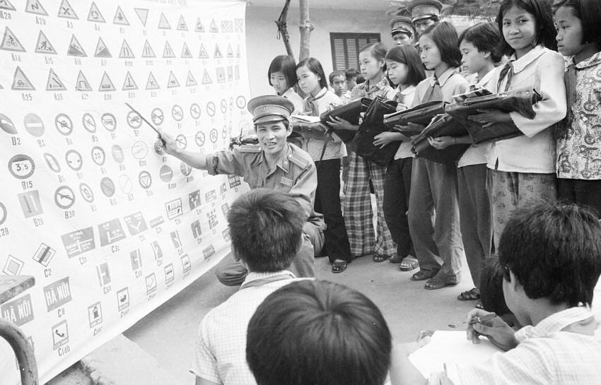 Cảnh sát giao thông quận Ba Đình (Hà Nội) phổ biến luật giao thông cho học sinh trường Tiểu học Chu Văn An (1982). (Ảnh: Xuân Lâm/TTXVN