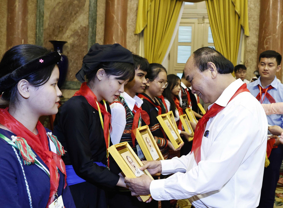 Chủ tịch nước Nguyễn Xuân Phúc tặng ảnh chân dung Bác Hồ cho các cháu thiếu nhi tiêu biểu các dân tộc. (Ảnh: Thống Nhất/TTXVN)