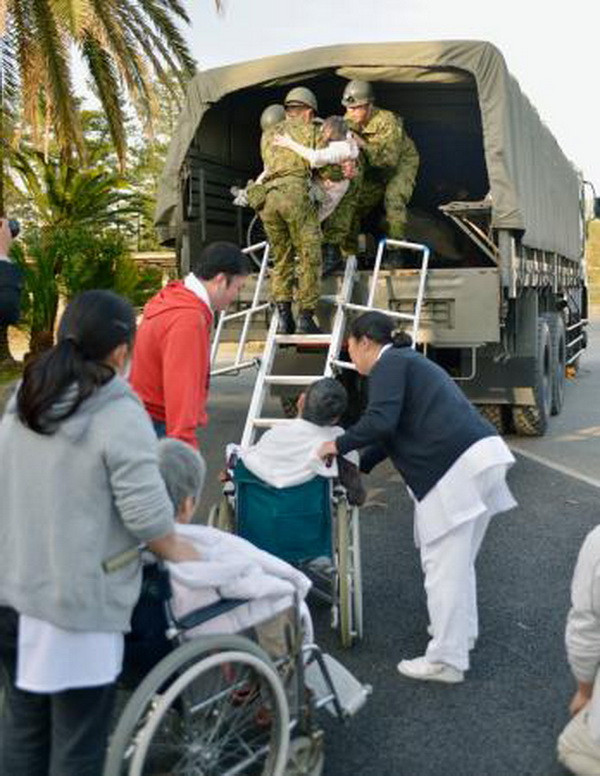 Lực lượng cứu hộ di chuyển các nạn nhân bị thương trong trận động đất. (Nguồn: Kyodo/TTXVN)