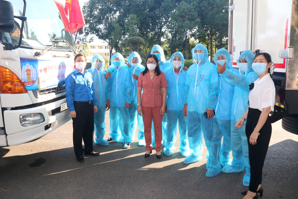 Đội ngũ tài xế được mặc đồ bảo hộ chống dịch trước khi chở hàng hóa, nhu yếu phẩm từ thành phố Phan Thiết đến hỗ trợ người dân Thành phố Hồ Chí Minh và tỉnh Bình Dương. (Ảnh: Nguyễn Thanh/TTXVN)