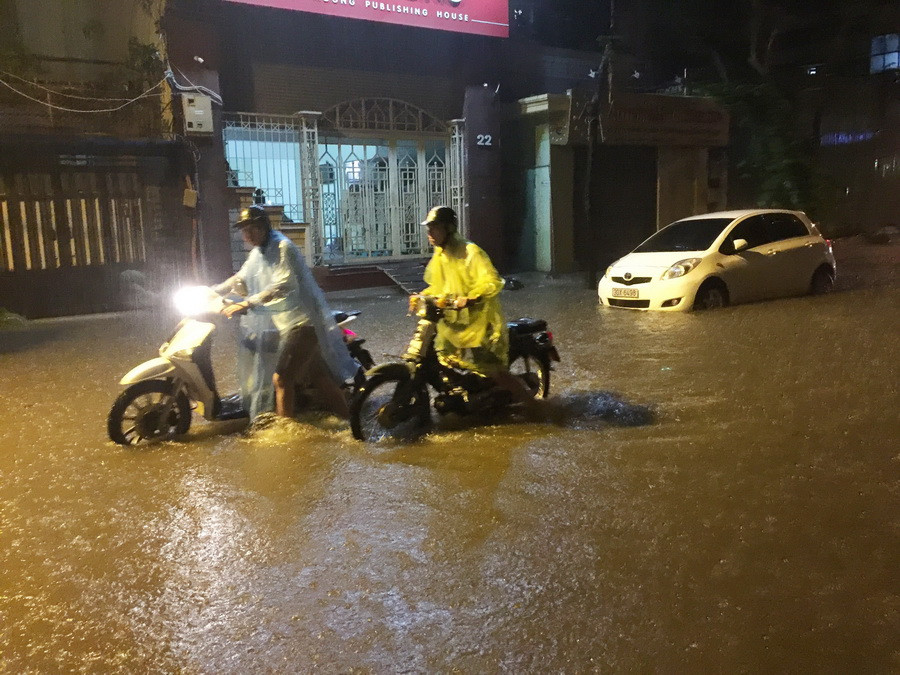 Một số ôtô, xe máy bị chết máy không thể lưu thông do ngập lụt trên phố Hàng Chuối, quận Hoàn Kiếm. (Ảnh: Lâm Khánh/TTXVN)