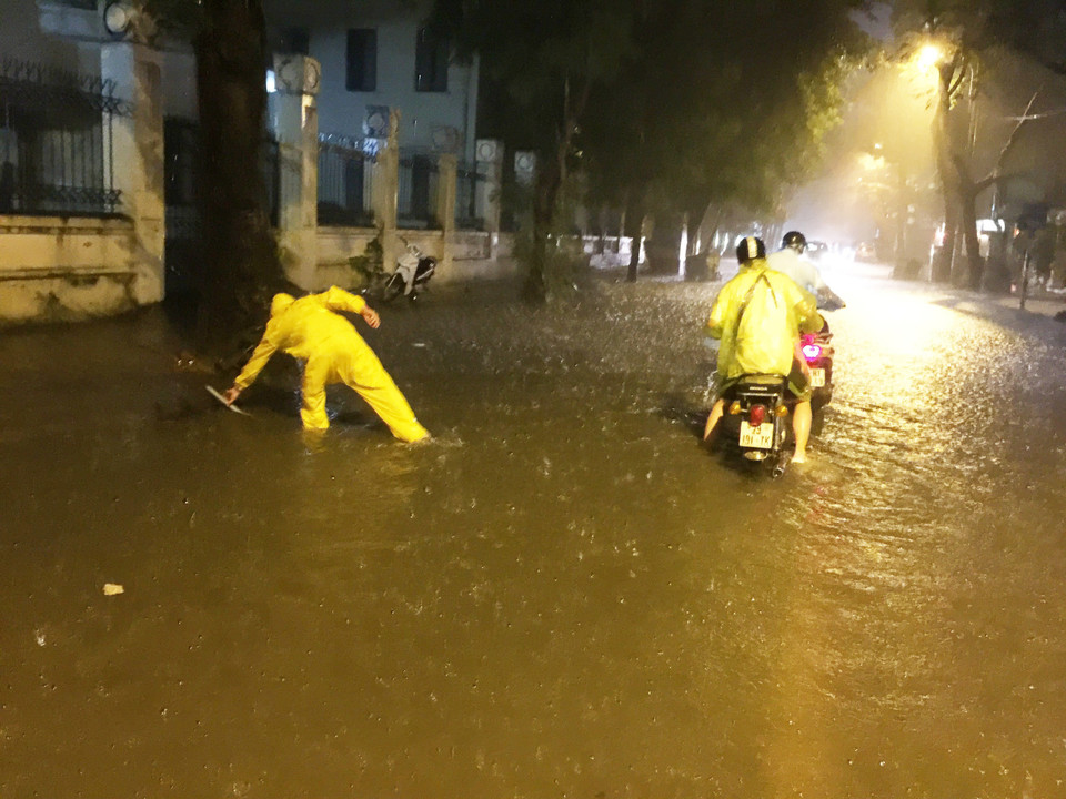 Nhân viên môi trường đô thị ứng trực mở cống thoát nước. (Ảnh: Lâm Khánh/TTXVN)